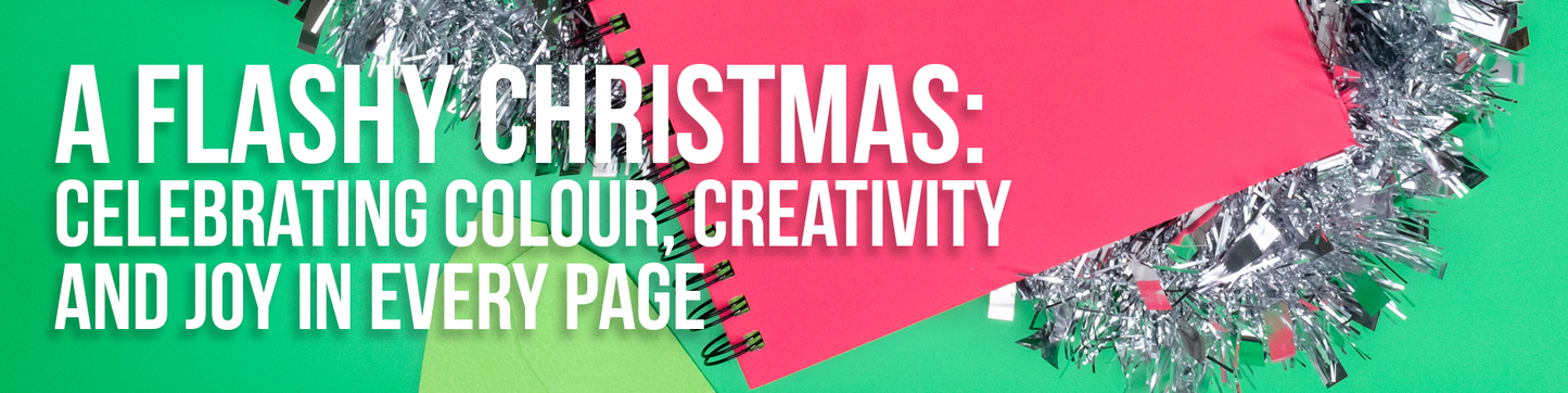 A red Flashy Sketchbook on a green background looking festive with tinsel around it and the title of the blog overlaid on the image