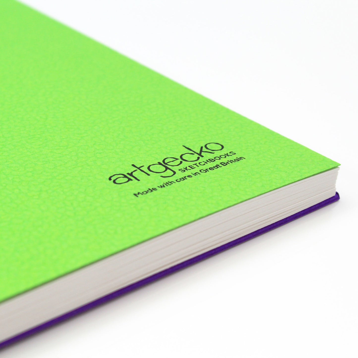 Close up of the corner of 'Flashy' all media sketchbook with green textured cover sheet on show and Artgecko branding.