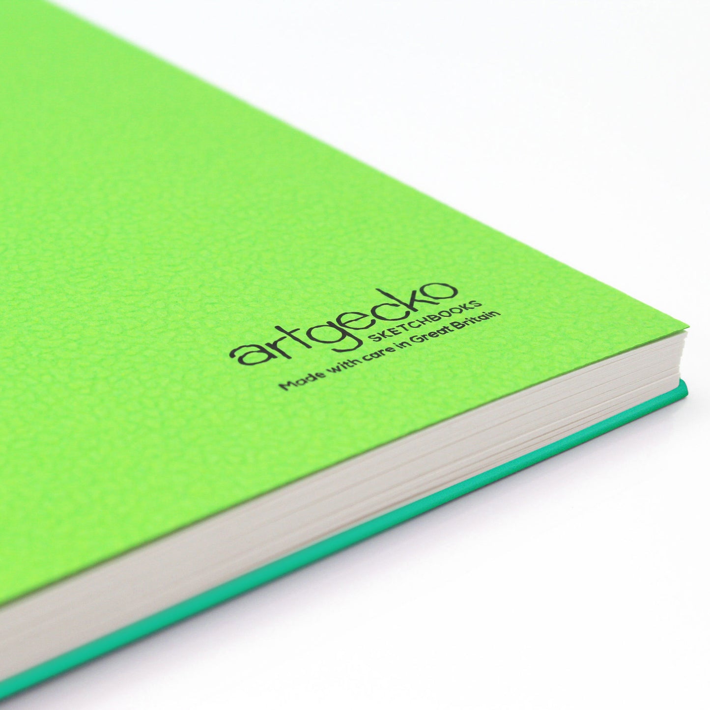 Close up of the corner of 'Flashy' all media sketchbook with green textured cover sheet on show and Artgecko branding.