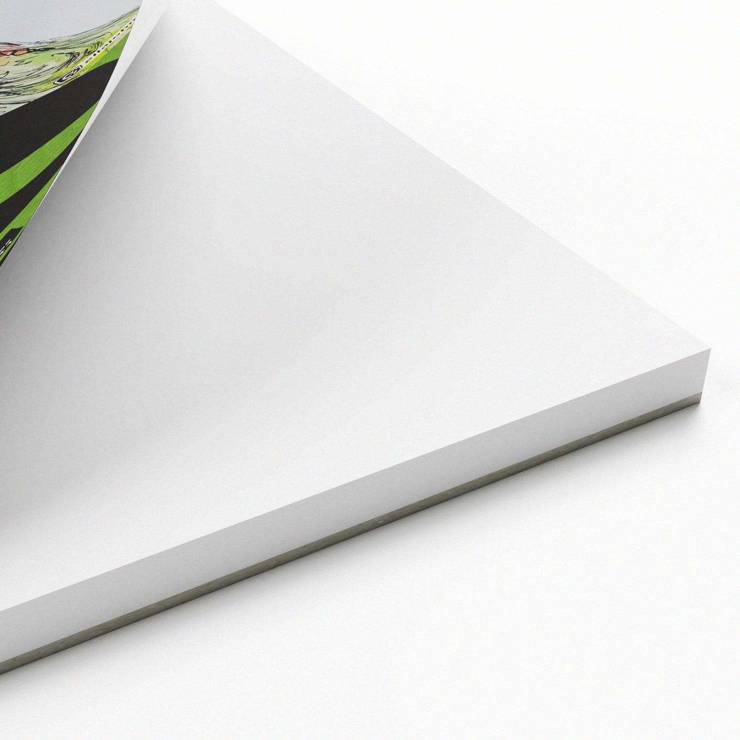 White paper sketch pad with a green and black corner section on a white background