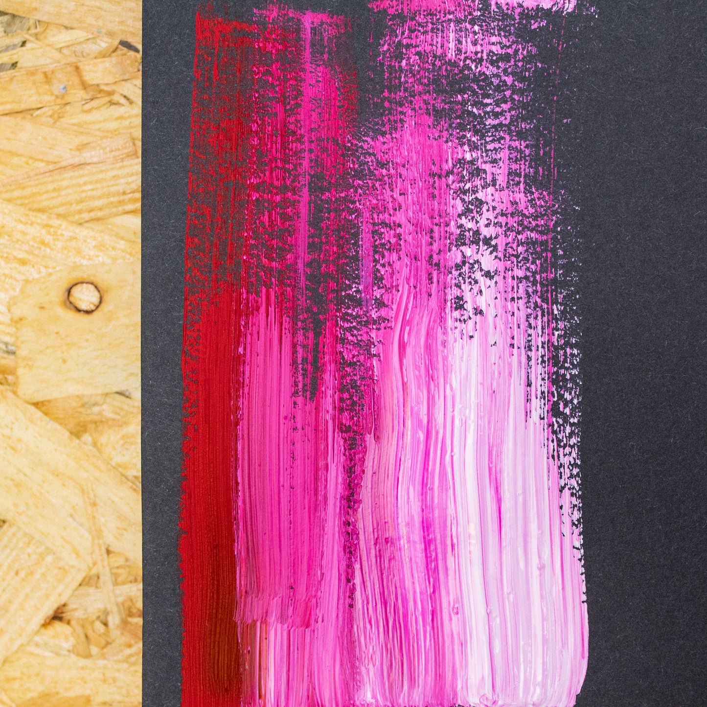 A swatch of paint on the page of a black toned sketch pad