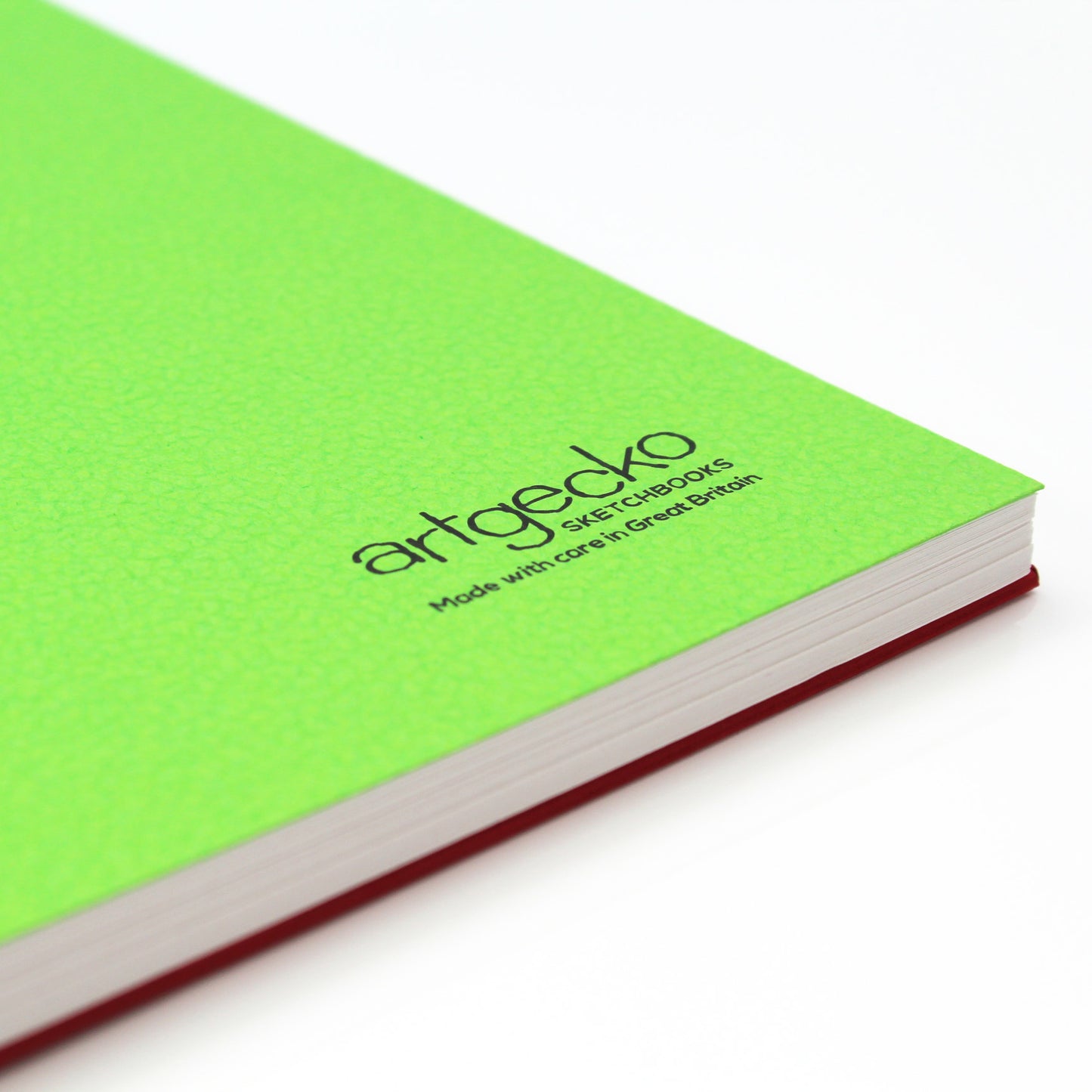 Close up of the corner of 'Flashy' all media sketchbook with green textured cover sheet on show and Artgecko branding.