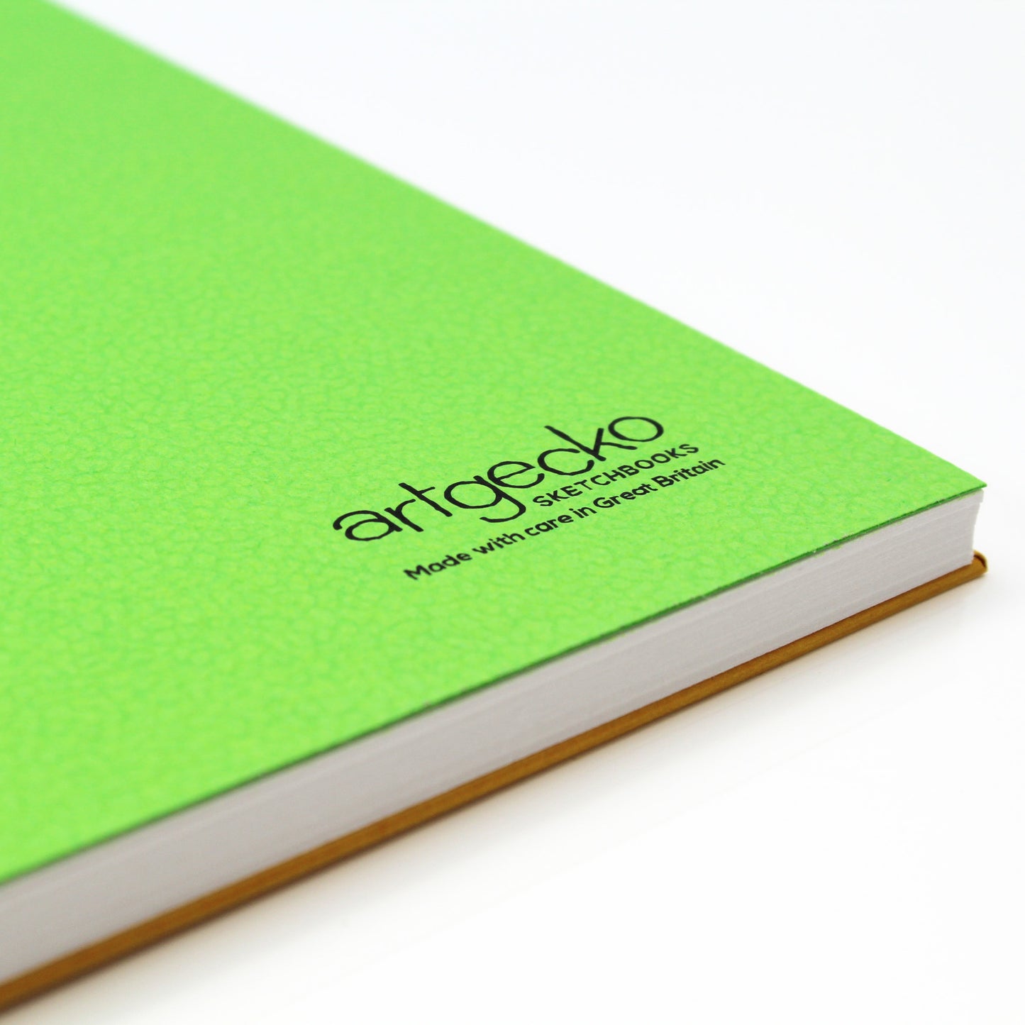Close up of the corner of 'Flashy' all media sketchbook with green textured cover sheet on show and Artgecko branding. FSC certified eco-friendly Artgecko FLASHY Yellow sketchbook UK made.