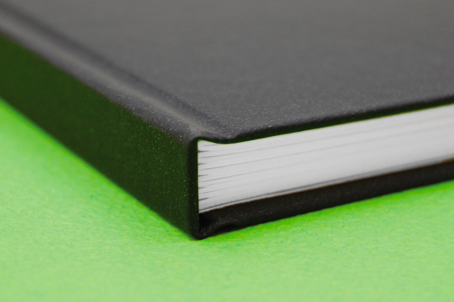 An Artgecko Classy All Media Sketchbook with black cover, case bound. Inside the book is 150gsm white cartridge paper and green textured cover sheet.